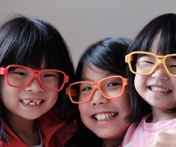 Three Asian children wear colorful big eyeglasses for eye vision concept