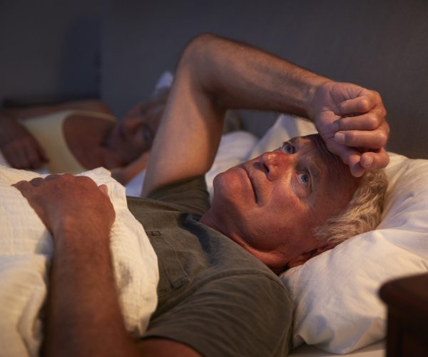 Worried Senior Man In Bed At Night Suffering With Insomnia